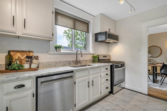 7439 Wellington Ave, University City, MO 63130 - kitchen with stainless steel appliances, white cabinetry, light marble finish floors, light stone counters, and rail lighting