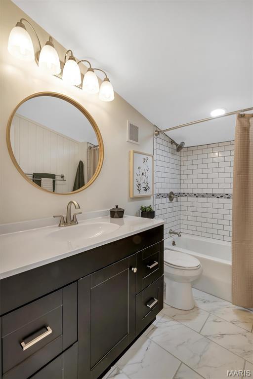 7439 Wellington Ave, University City, MO 63130 - full bathroom featuring vanity, marble finish floors, and shower / bath combo