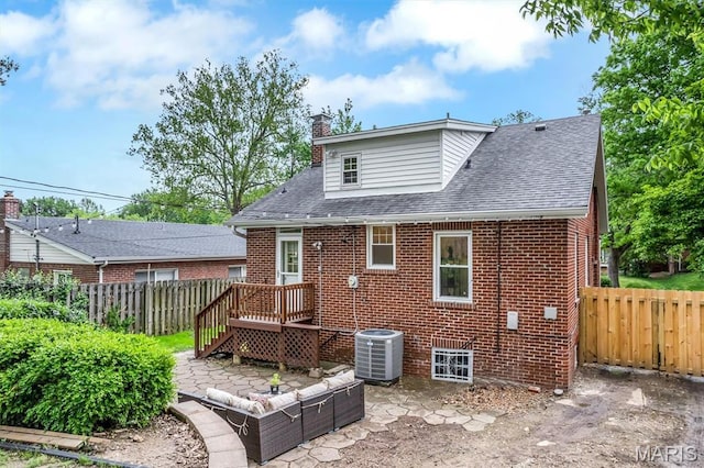 7439 Wellington Ave, University City, MO 63130 - rear view of property featuring a chimney, brick siding, a wooden deck, roof with shingles, and a patio