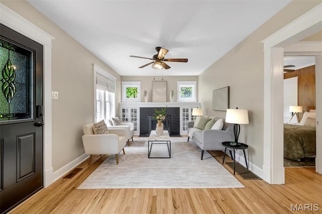 7439 Wellington Ave, University City, MO 63130 - living room featuring a ceiling fan, a fireplace, and light wood-style floors