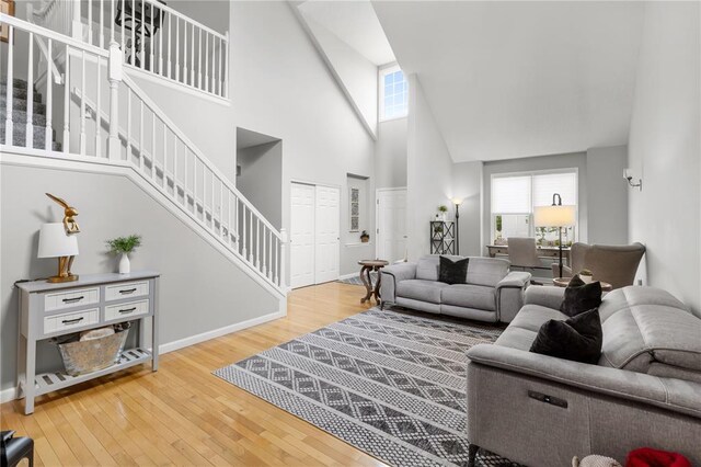 2056 Hawks Landing Dr, Lake St Louis, MO 63367 - living area with stairway, high vaulted ceiling, wood-type flooring, and healthy amount of natural light
