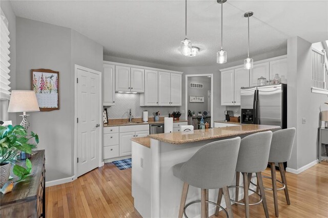 2056 Hawks Landing Dr, Lake St Louis, MO 63367 - kitchen featuring stainless steel appliances, a sink, white cabinetry, and light wood finished floors