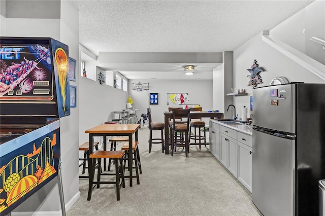 2056 Hawks Landing Dr, Lake St Louis, MO 63367 - kitchen featuring freestanding refrigerator, light colored carpet, a sink, a textured ceiling, and ceiling fan