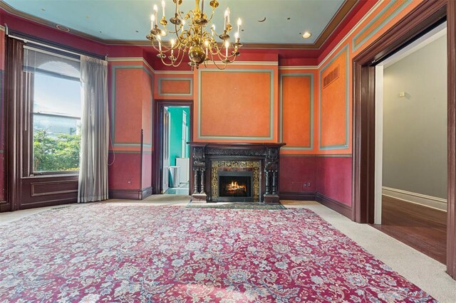 3534 Washington Ave, Saint Louis, MO 63103 - unfurnished living room featuring a chandelier, crown molding, a premium fireplace, baseboards, and carpet flooring