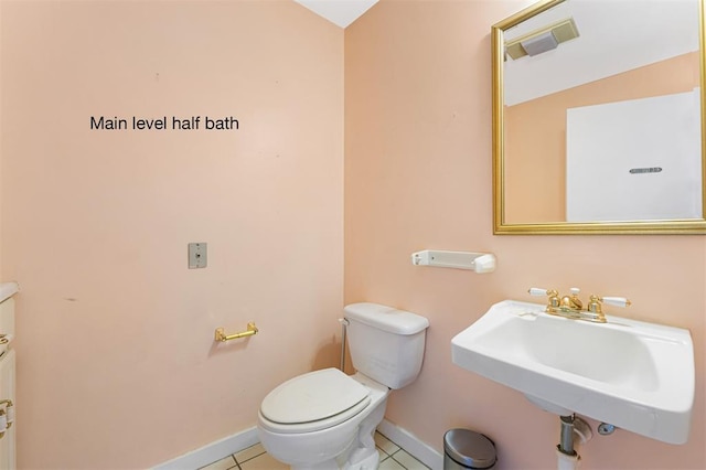 3534 Washington Ave, Saint Louis, MO 63103 - bathroom featuring a sink, baseboards, toilet, and tile patterned floors