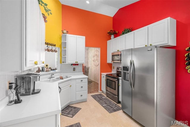 13116 Ambrose Ct, Black Jack, MO 63033 - kitchen featuring appliances with stainless steel finishes, high vaulted ceiling, a sink, white cabinetry, and open shelves
