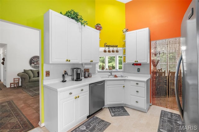 13116 Ambrose Ct, Black Jack, MO 63033 - kitchen with stainless steel appliances, a sink, a towering ceiling, white cabinets, and light countertops