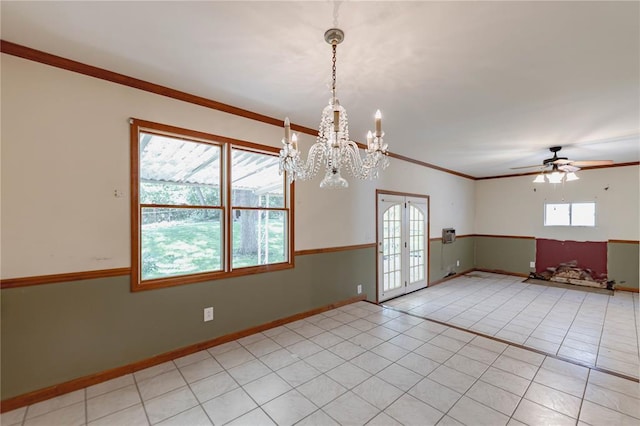 spare room with french doors, baseboards, a chandelier, a ceiling fan, and crown molding