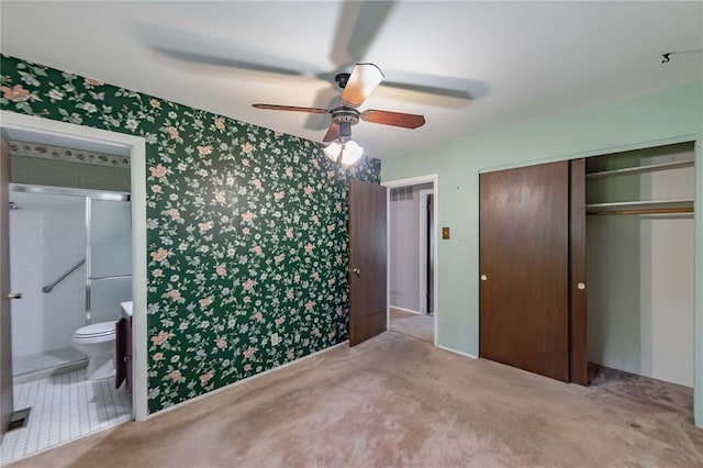 bedroom with wallpapered walls, a closet, connected bathroom, carpet floors, and ceiling fan