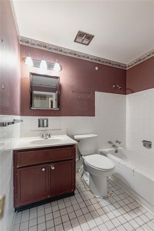 full bathroom with tile walls, tile patterned floors, toilet, shower / washtub combination, and vanity