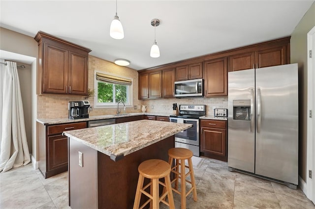14 Heavenly Valley Dr, Dardenne Prairie, MO 63368 - kitchen featuring stainless steel appliances, a sink, backsplash, hanging light fixtures, and a center island