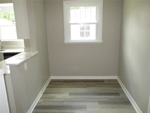 unfurnished dining area featuring light wood-style flooring and baseboards