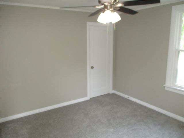 carpeted empty room featuring ceiling fan and baseboards