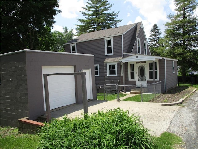 view of front of property with a fenced front yard, an outdoor structure, a gate, and concrete driveway