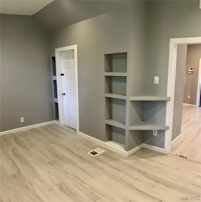 5379 Wabada Ave, Saint Louis, MO 63112 - empty room with wood finished floors, lofted ceiling, and built in shelves