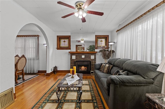6266 Marmaduke Ave, Saint Louis, MO 63139 - living room with ceiling fan, arched walkways, wood finished floors, a fireplace, and baseboards