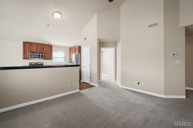 533 Bramblett Hls, Ofallon, MO 63366 - kitchen with stainless steel appliances, dark carpet, baseboards, high vaulted ceiling, and hanging light fixtures