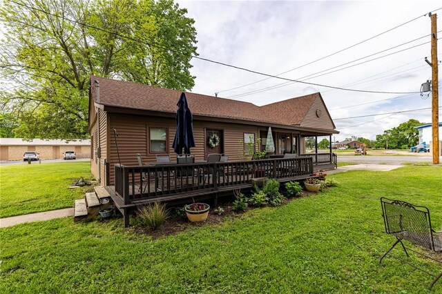 506 N Garfield, East Prairie, MO 63845 - view of front of property featuring a front lawn, a shingled roof, and a deck