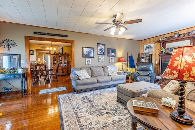 506 N Garfield, East Prairie, MO 63845 - living room featuring a chandelier, a ceiling fan, hardwood / wood-style floors, ornamental molding, and wooden walls