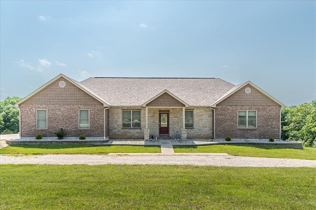 ranch-style house featuring a front lawn and stone siding