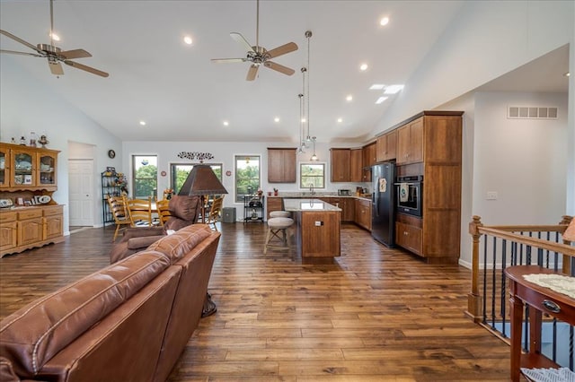 living area with ceiling fan, high vaulted ceiling, dark wood-type flooring, and recessed lighting