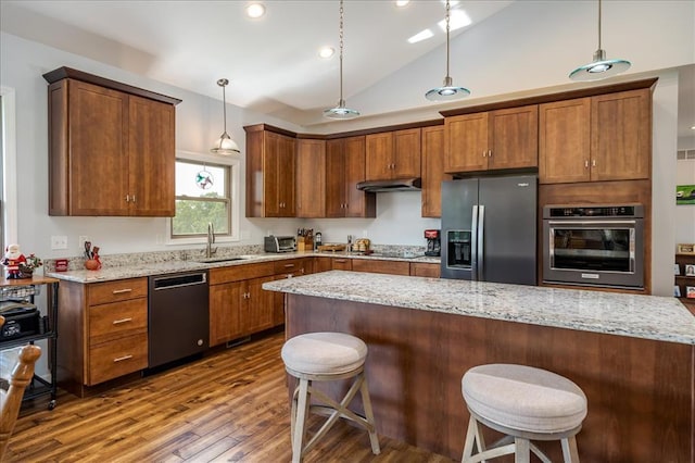 kitchen with stainless steel fridge, wall oven, dishwasher, dark wood-type flooring, and black electric stovetop
