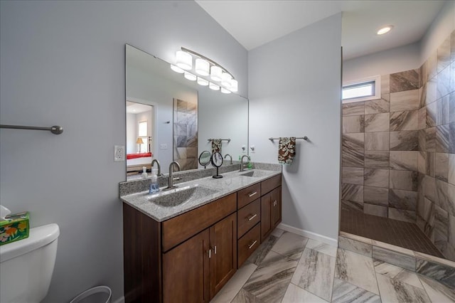 full bathroom with double vanity, walk in shower, marble look tiles, and toilet