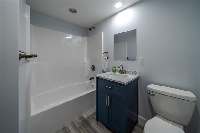 full bath featuring wood finished floors, toilet, bathing tub / shower combination, and vanity