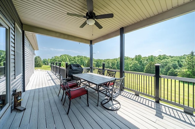 deck featuring outdoor dining space, area for grilling, and ceiling fan