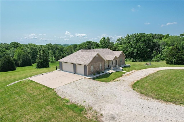 view of front of house featuring a front lawn, a garage, and gravel driveway