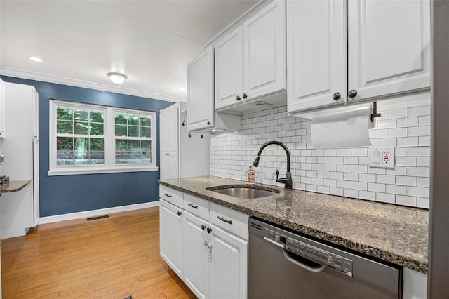 kitchen with dishwasher, a sink, white cabinets, decorative backsplash, and light wood finished floors