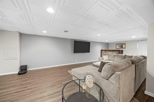 living area featuring recessed lighting, baseboards, wood finished floors, and an ornate ceiling