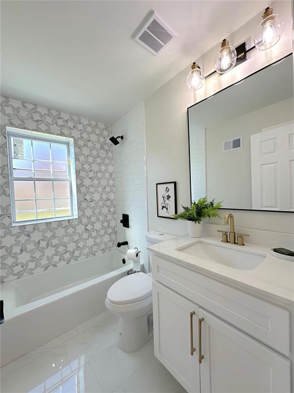 full bathroom featuring shower / bathtub combination, toilet, vanity, and marble finish floors