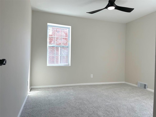 spare room featuring carpet floors, a ceiling fan, and baseboards