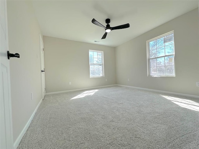 carpeted spare room with baseboards and a ceiling fan