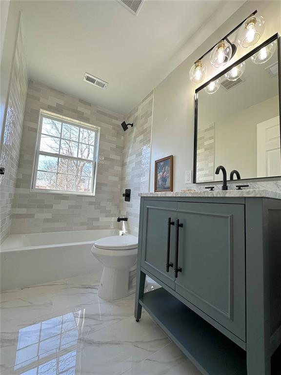 full bathroom with toilet, bathing tub / shower combination, vanity, and marble finish floors