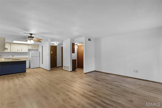 1380 Heritage Lndg Unit 105, Frontier Township, MO 63303 - unfurnished living room featuring light wood-type flooring, baseboards, a sink, and ceiling fan