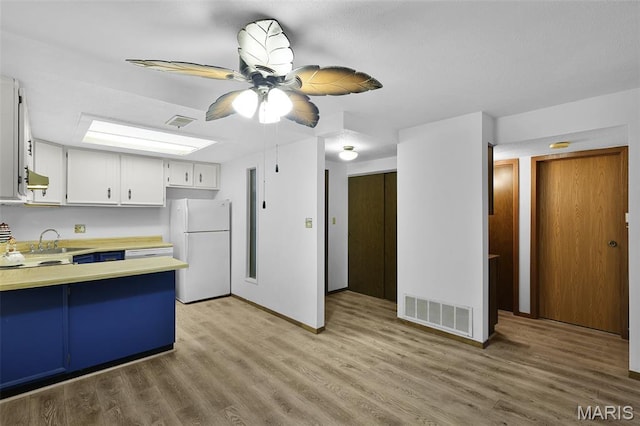 1380 Heritage Lndg Unit 105, Frontier Township, MO 63303 - kitchen featuring freestanding refrigerator, a ceiling fan, a sink, light wood-style floors, and exhaust hood