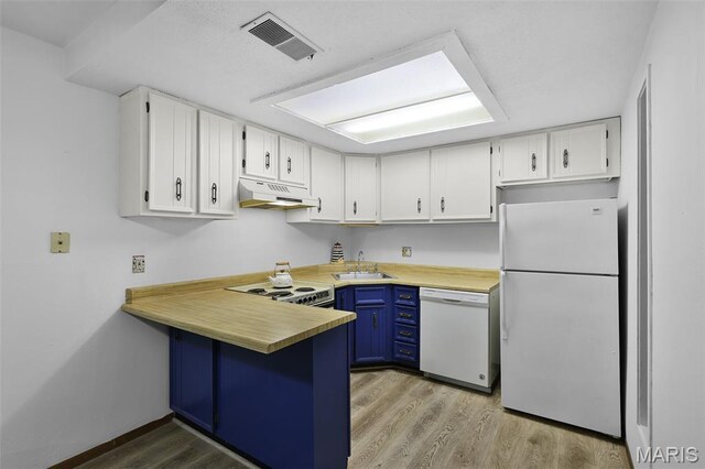 1380 Heritage Lndg Unit 105, Frontier Township, MO 63303 - kitchen featuring white appliances, a sink, under cabinet range hood, a peninsula, and white cabinets