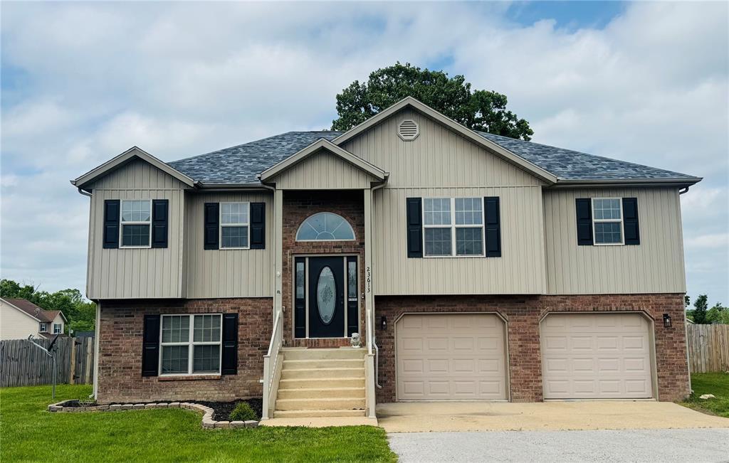 23613 Reward Rd, Waynesville, MO 65583 - split foyer home with brick siding, a shingled roof, a garage, and concrete driveway