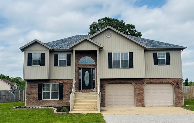 23613 Reward Rd, Waynesville, MO 65583 - split foyer home with brick siding, a shingled roof, a garage, and concrete driveway