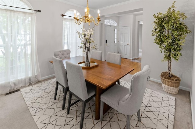 dining space with a chandelier, crown molding, and baseboards