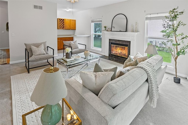 living area with light carpet, a premium fireplace, and baseboards