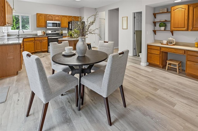 dining space with light wood-style floors and baseboards