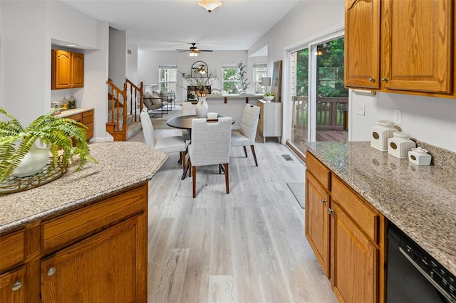 kitchen with black dishwasher, light wood-style floors, ceiling fan, and brown cabinetry