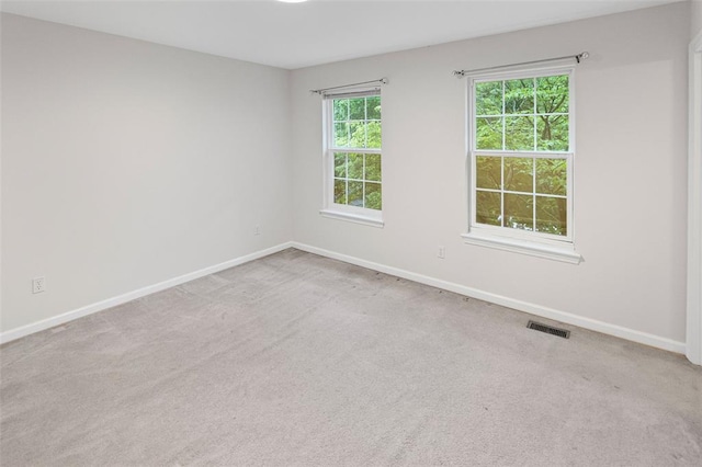 carpeted spare room featuring baseboards