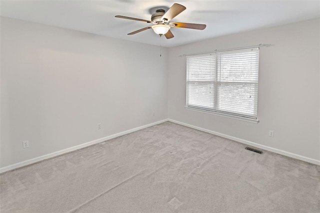 carpeted empty room with ceiling fan and baseboards