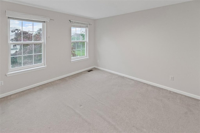 carpeted empty room featuring baseboards