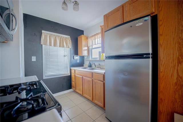 225 Haller Ave, East Alton, IL 62024 - kitchen featuring appliances with stainless steel finishes, a sink, light tile patterned flooring, light countertops, and baseboards