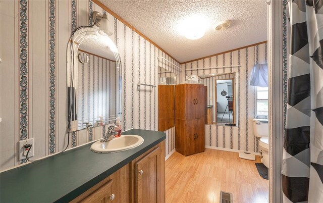 442 County Road 6250, Salem, MO 65560 - full bathroom with wallpapered walls, wood finished floors, a textured ceiling, crown molding, and vanity